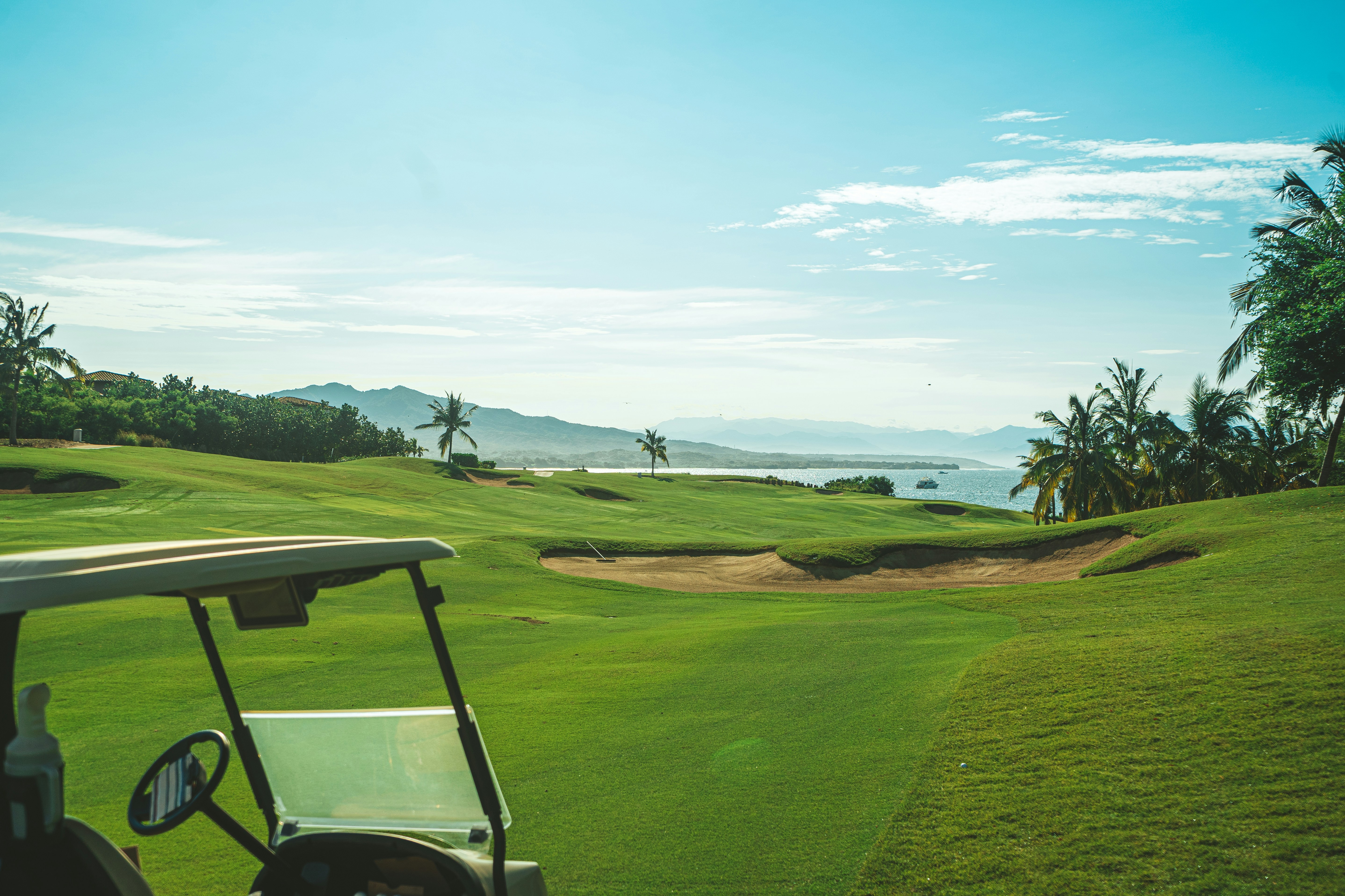 Un carrito de golf en un campo de golf con vista al océano