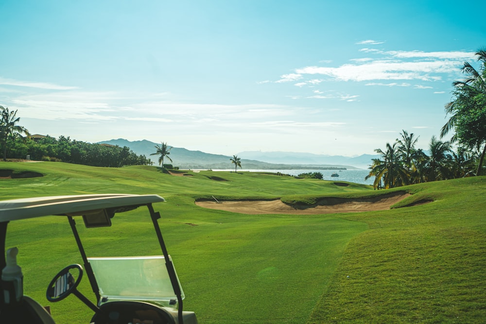a golf cart on a golf course with a view of the ocean