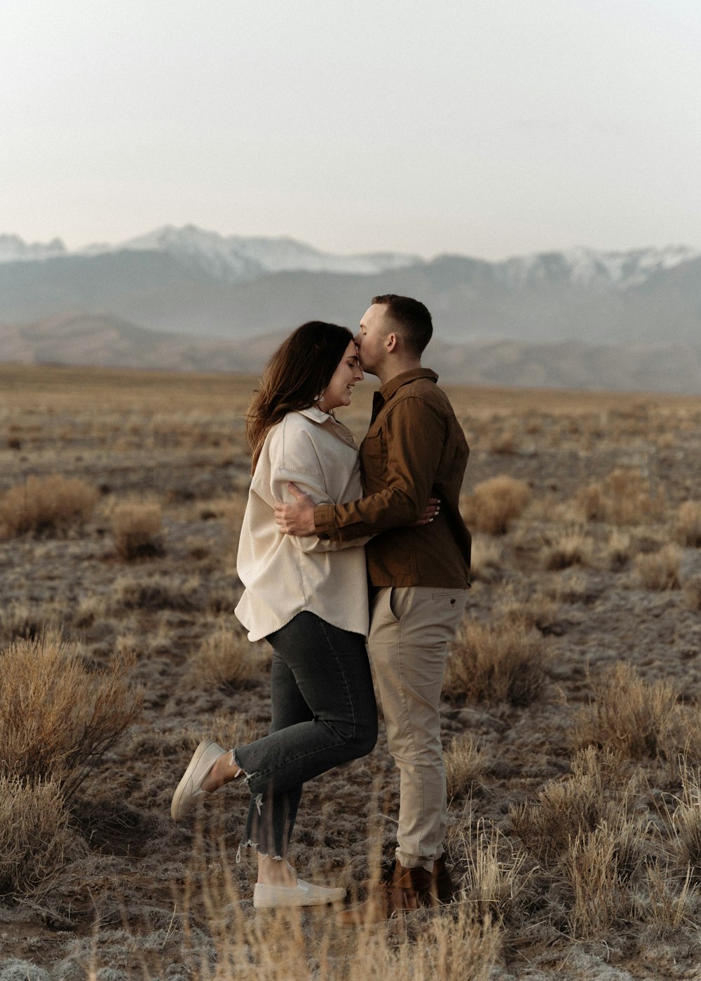 a man and a woman kissing in a field