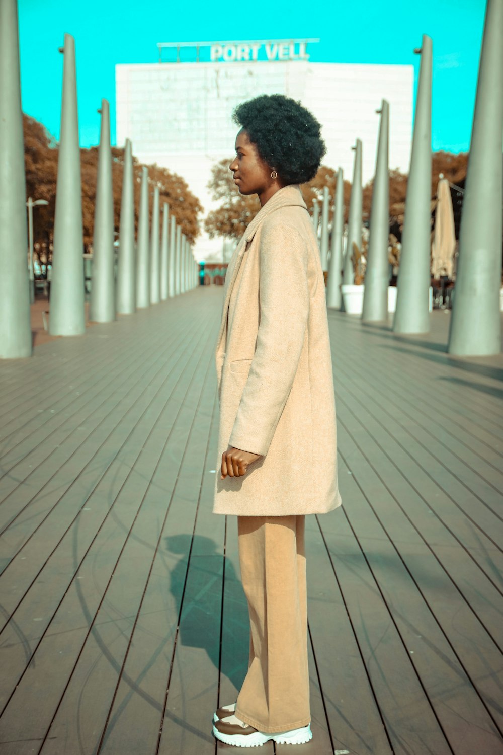 a woman standing on a boardwalk in a suit