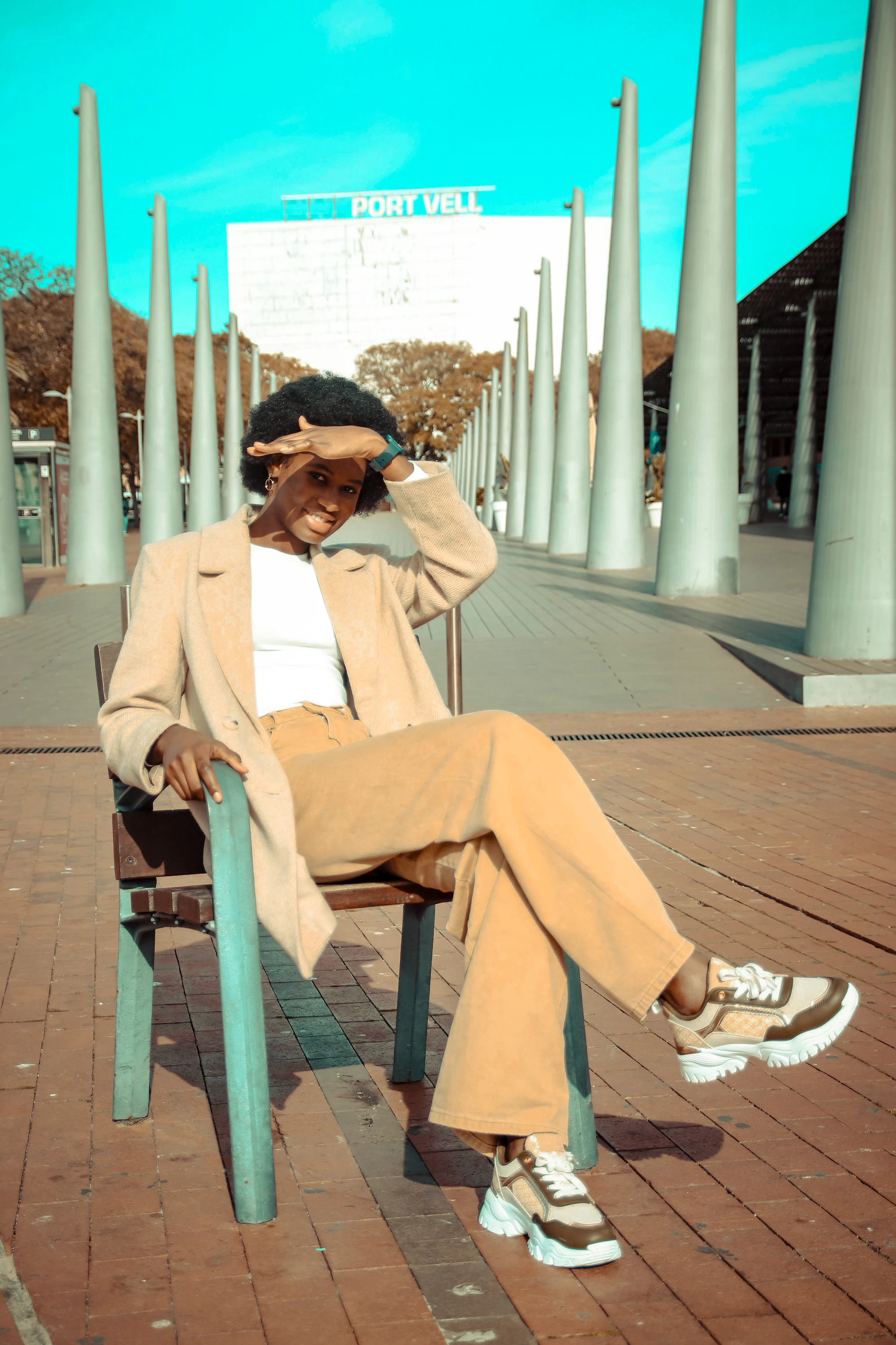 A man in a beige suit sitting on a chair outdoors