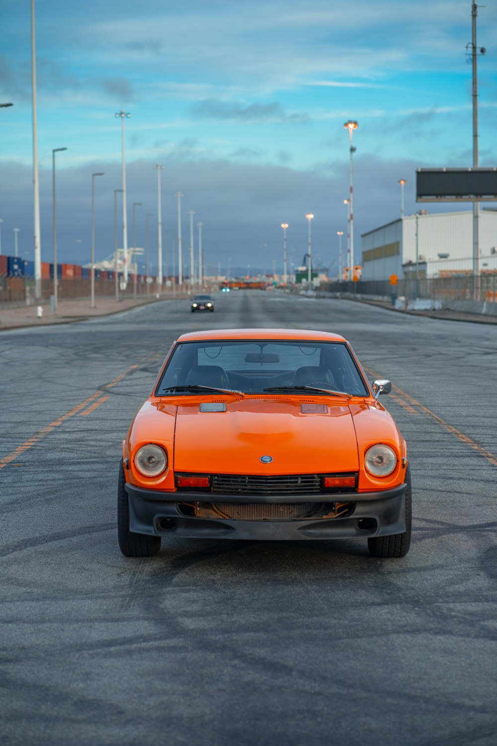 an orange car is parked on the side of the road