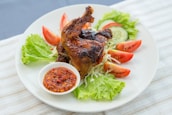 a white plate topped with meat and vegetables