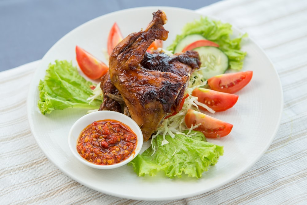 a white plate topped with meat and vegetables