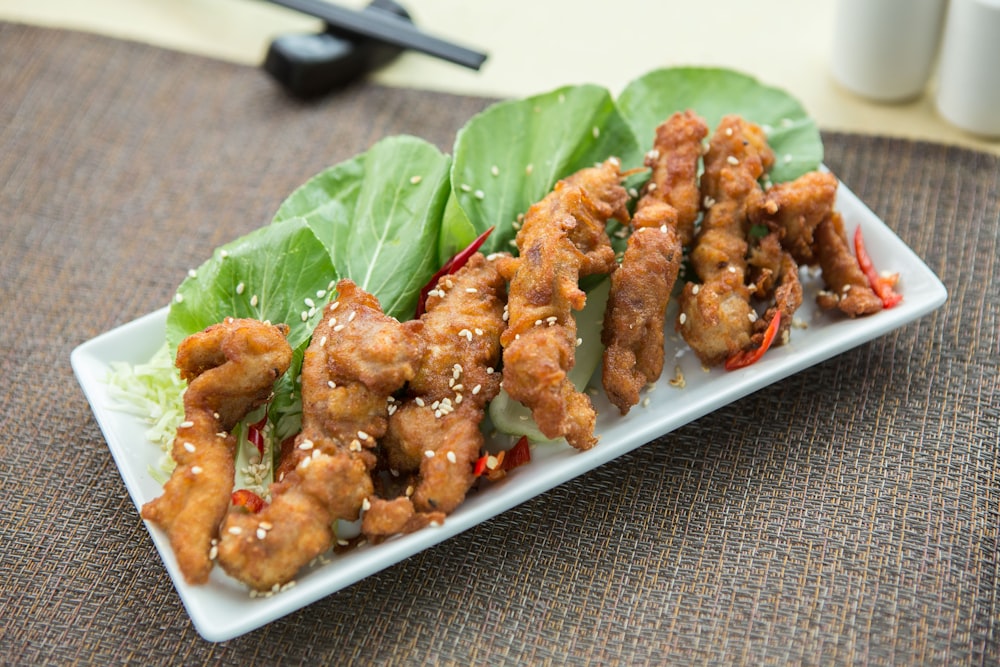 a white plate topped with chicken and lettuce