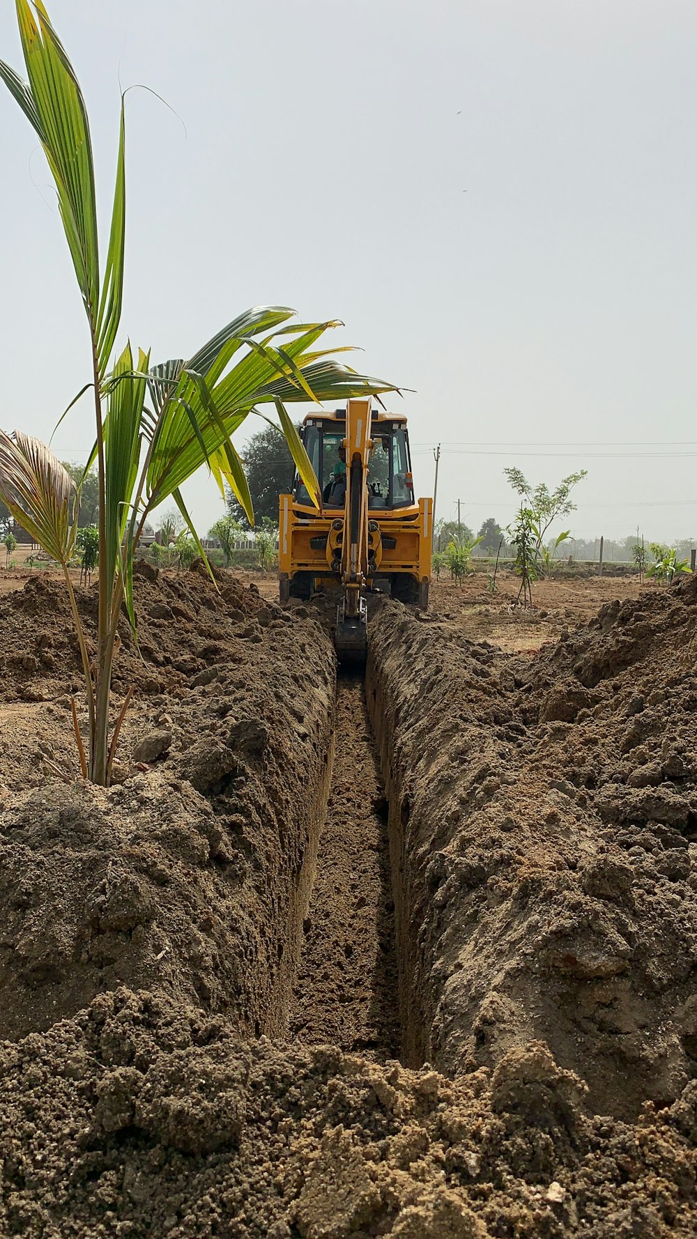 a tractor digging a trench in a field