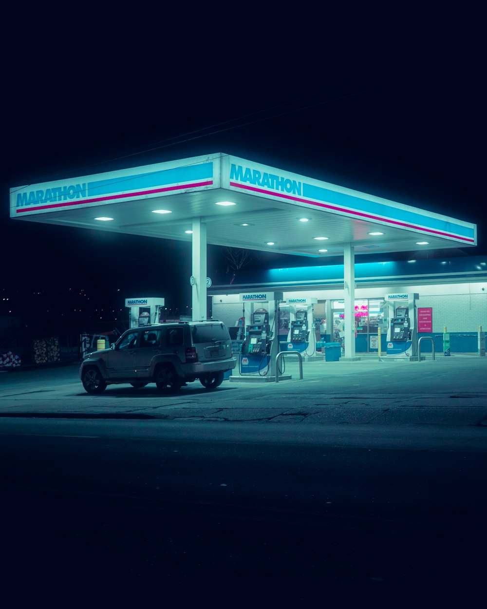 a gas station at night with a truck parked in front of it