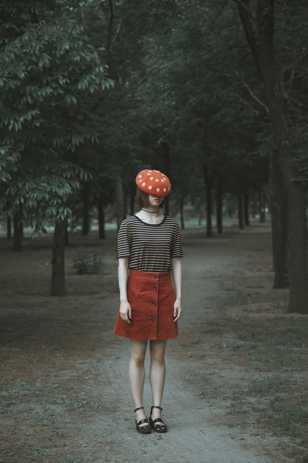 a woman wearing a polka dot hat and a red skirt