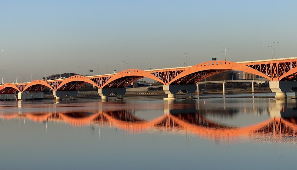 an orange bridge over a body of water