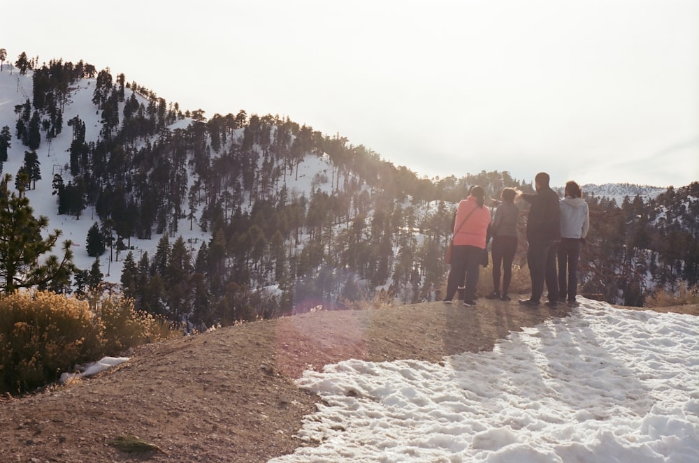 a group of people standing on top of a snow covered slope