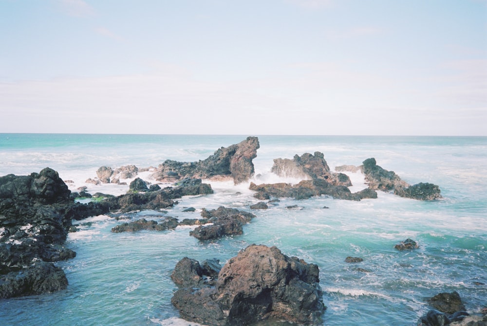 a view of the ocean with rocks in the foreground