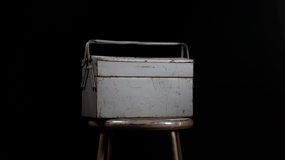 una caja de metal sentada encima de un taburete