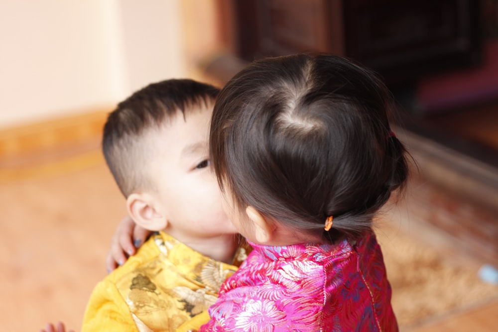 a little girl kissing a little boy on the cheek