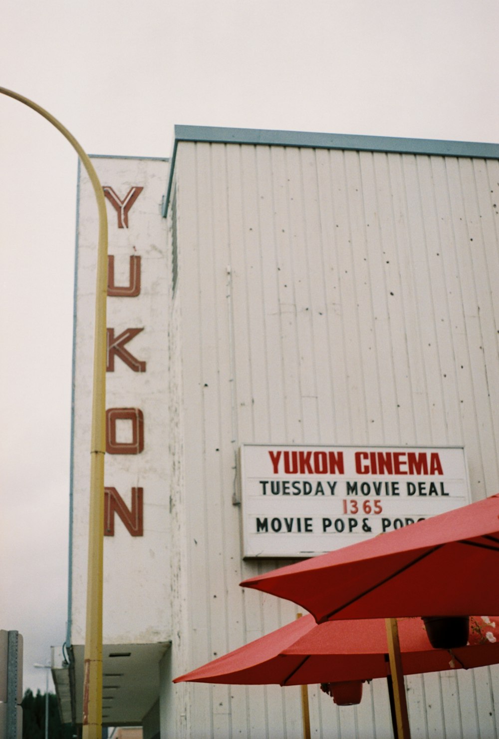 a movie theater with red umbrellas in front of it