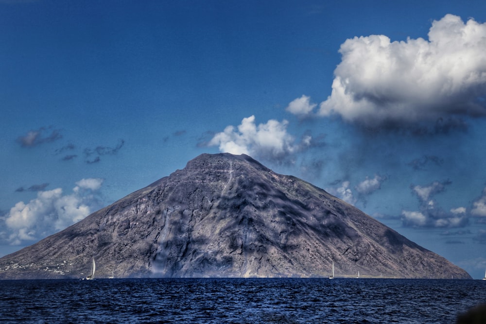 a large mountain with a very tall peak in the middle of the ocean