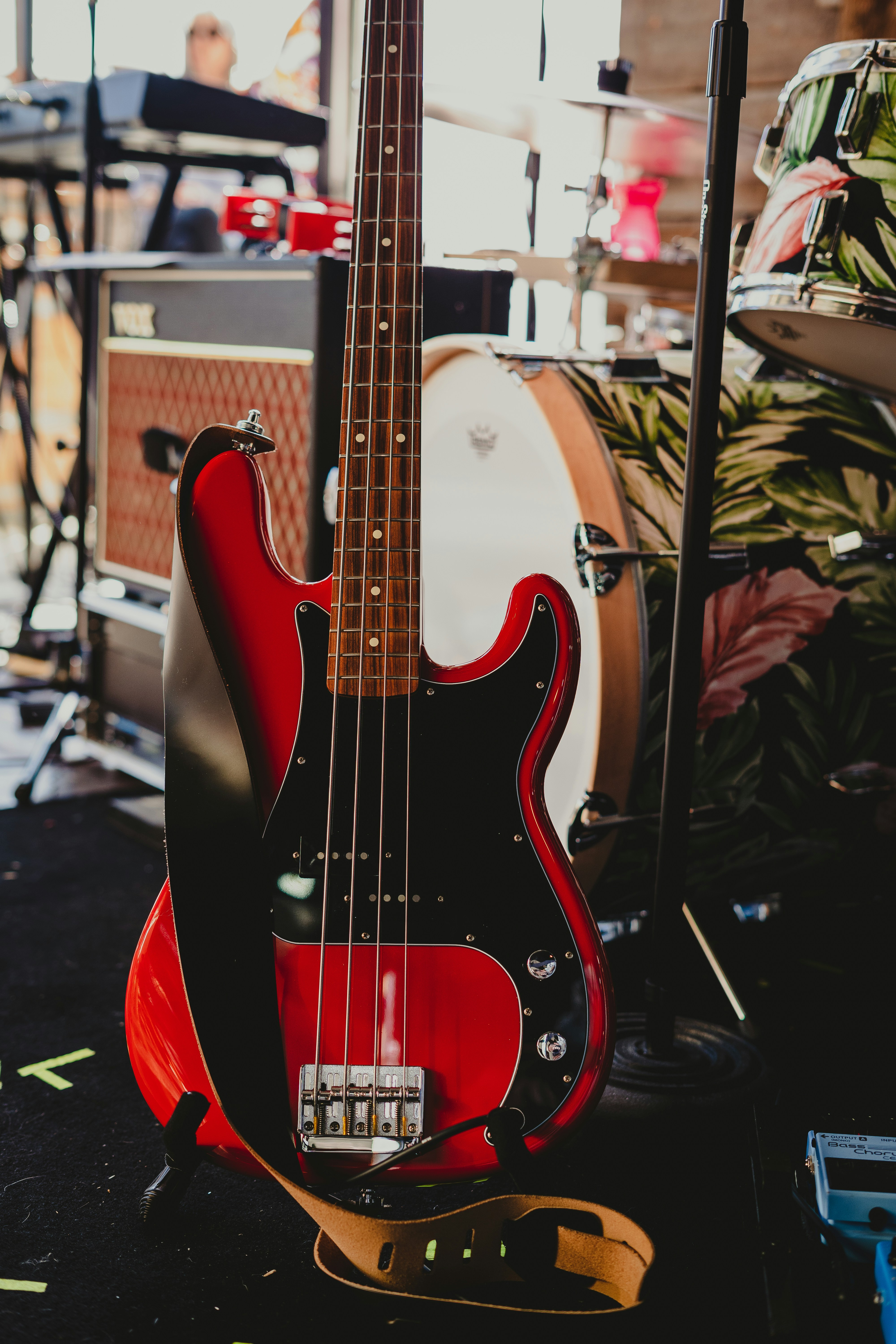 a red and black bass guitar sitting on top of a table