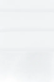 a man in a suit and tie standing in front of a white wall