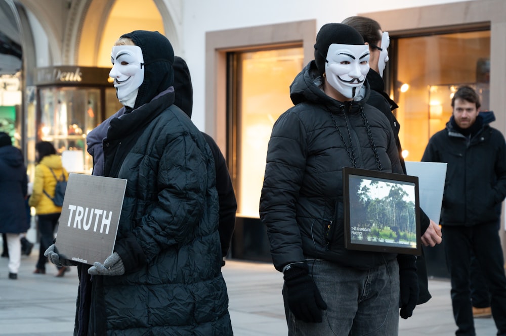a group of people with masks on holding signs