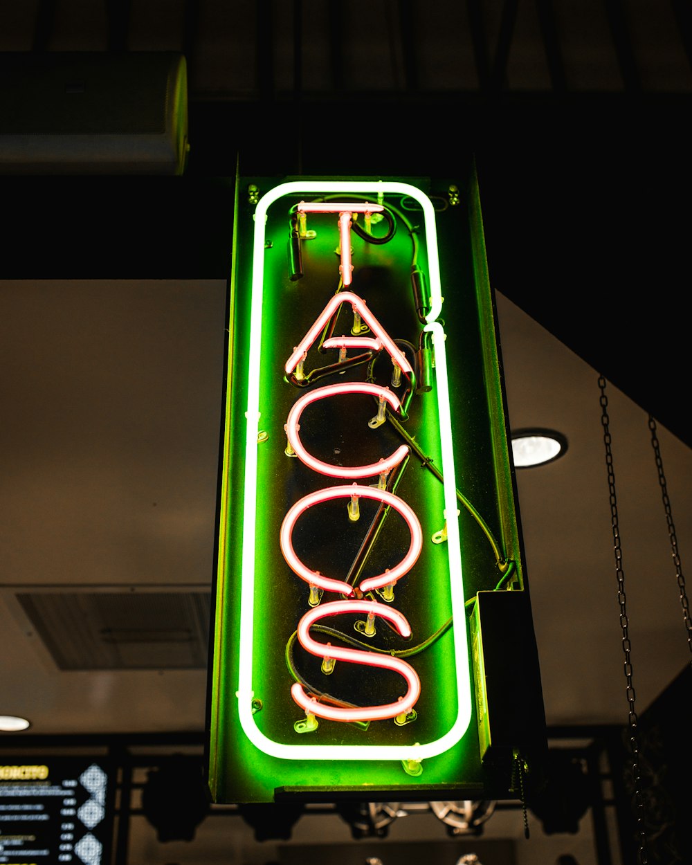 a neon sign hanging from the side of a building