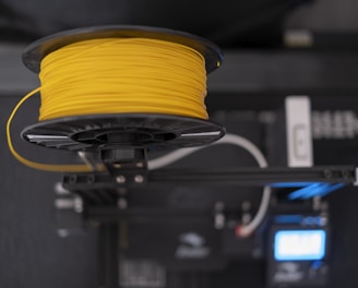 a spool of yellow wire sitting on top of a machine