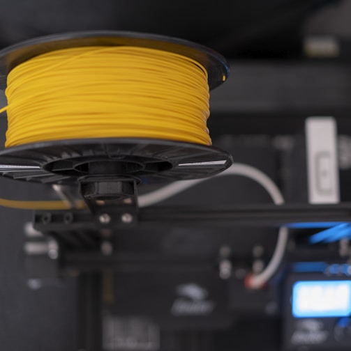 a spool of yellow wire sitting on top of a machine