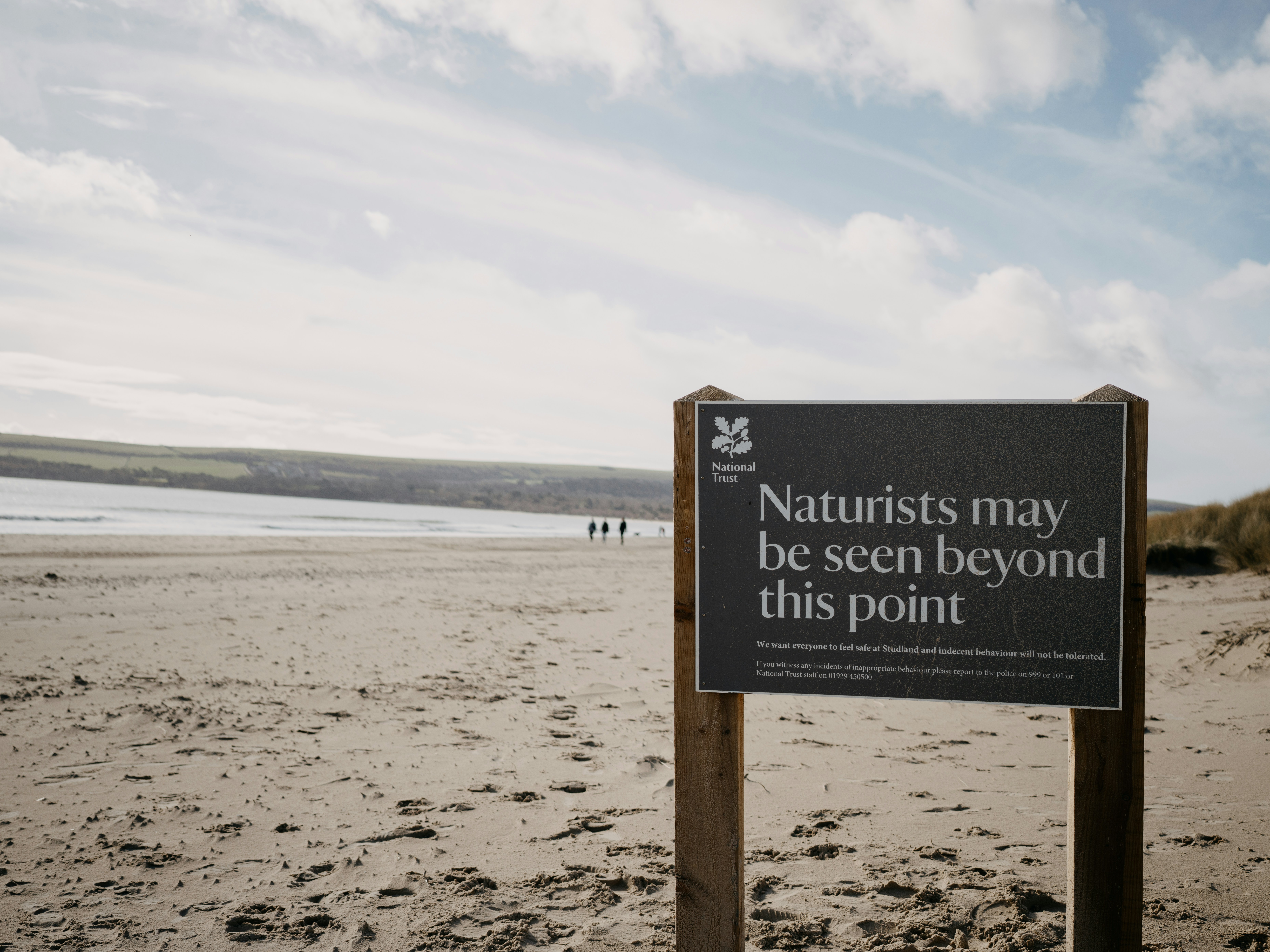 a sign on a beach that says naturalists may be seen beyond this point, 
