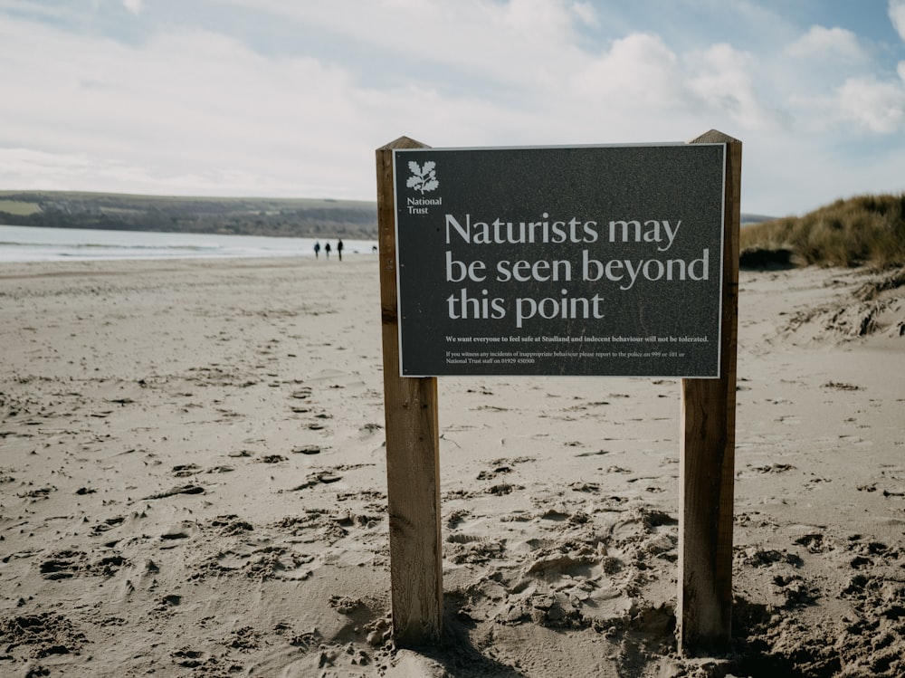 a sign on a beach that says naturalists may be seen beyond this point