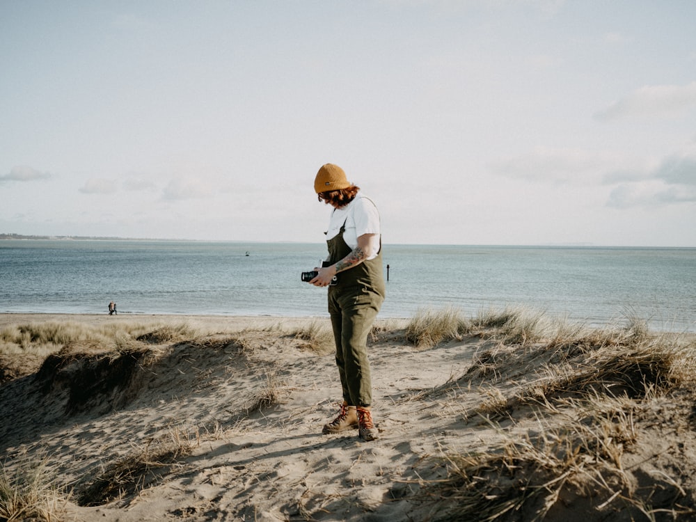 a person standing on a beach with a camera