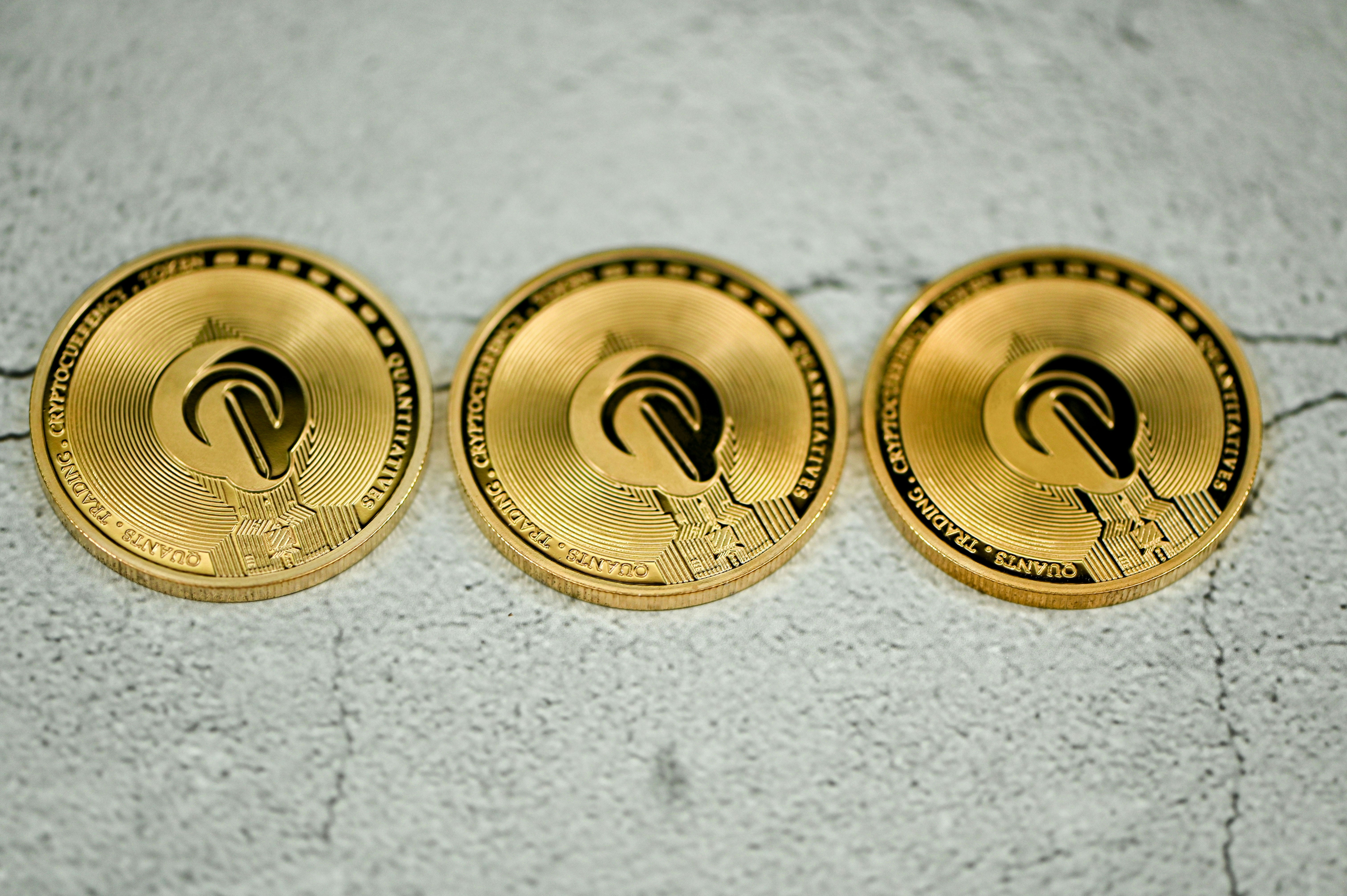 Three QEST coins on the ground