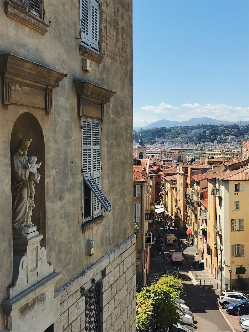 a city street with a statue on the side of a building