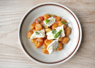 a white plate topped with food on top of a wooden table