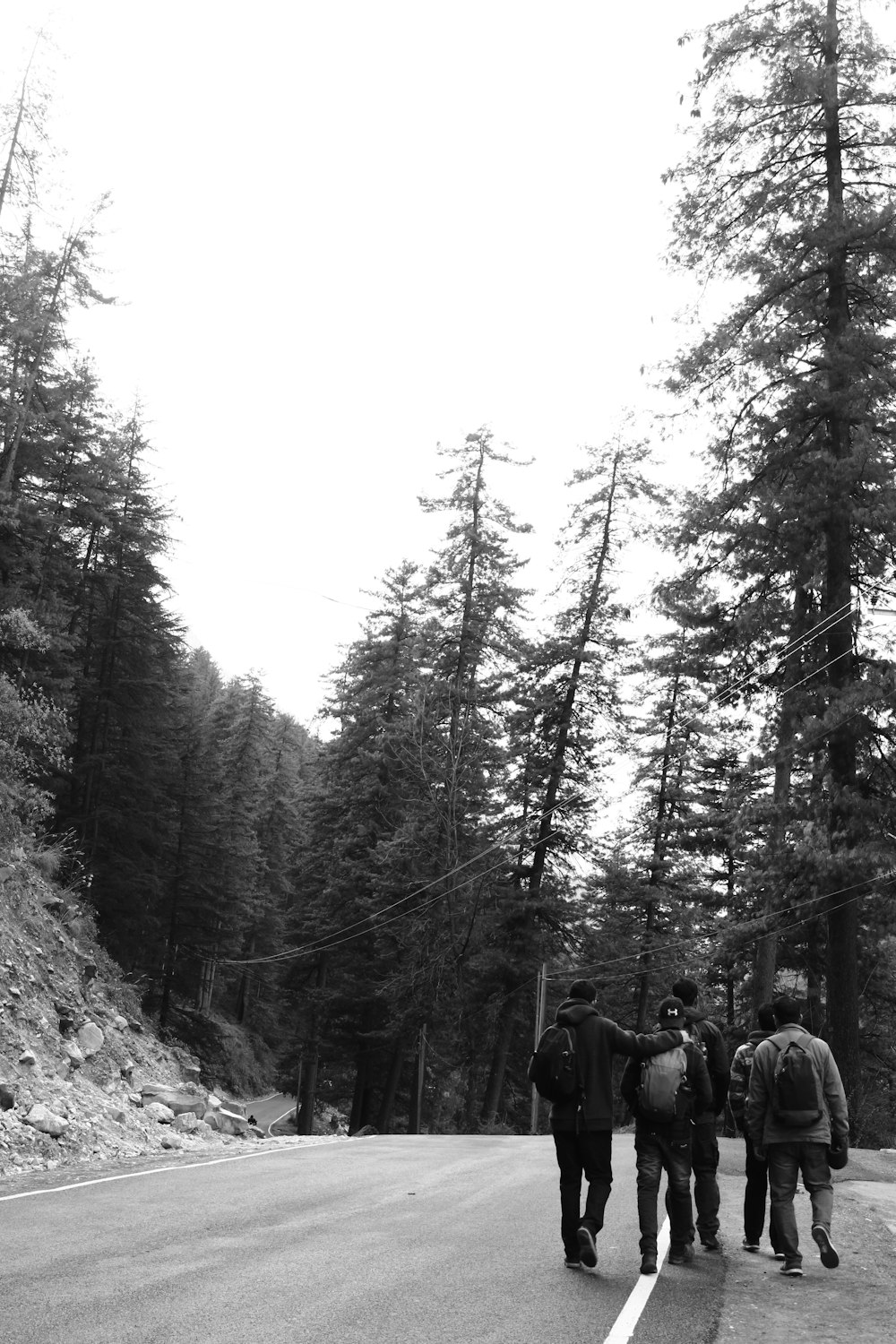 a group of people standing on the side of a road