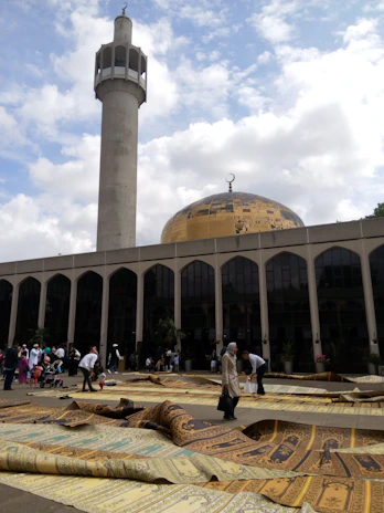 A peaceful Berlin mosque with people entering for prayer on a sunny day.