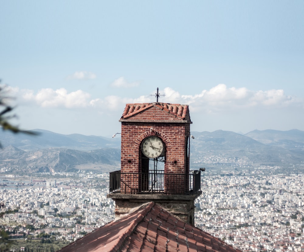 a clock tower on top of a building with a city in the background