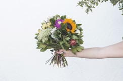a person holding a bouquet of flowers in their hand