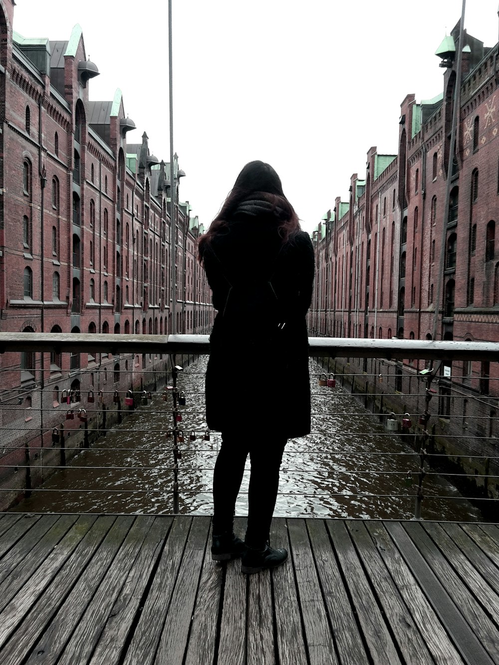 a person standing on a wooden bridge over a body of water