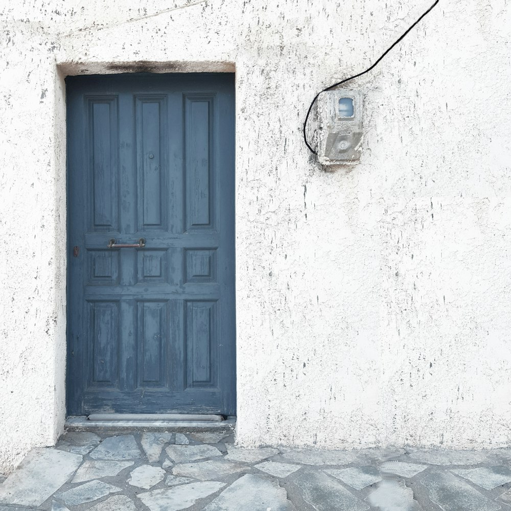 a blue door on a white stucco building