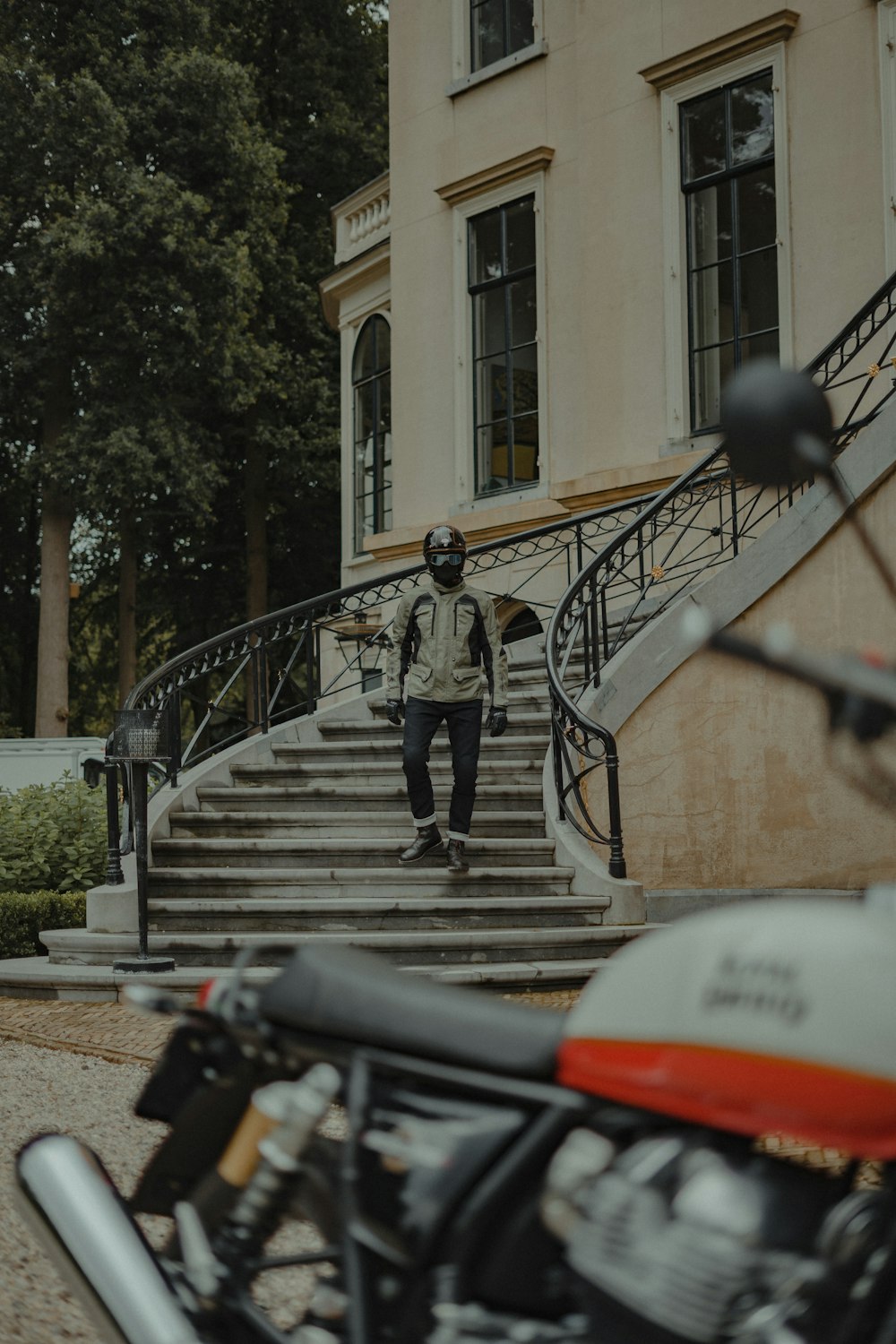 a man walking down a flight of stairs next to a motorcycle