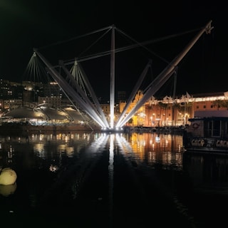 Night shot of the 'Ola en el Puerto' installation illuminating the harbor area.