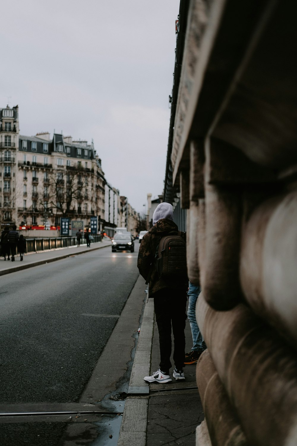 a couple of people standing on the side of a road