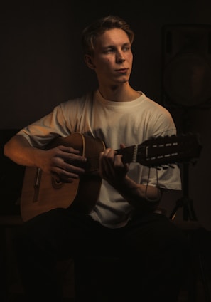 a man playing a guitar in a dark room