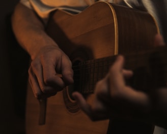 a man playing a guitar in a dark room