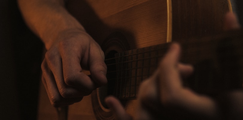 a man playing a guitar in a dark room