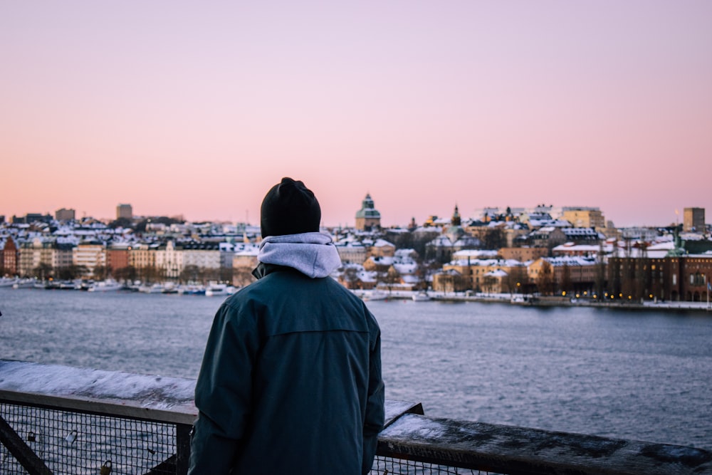 a person standing on a bridge looking at the water