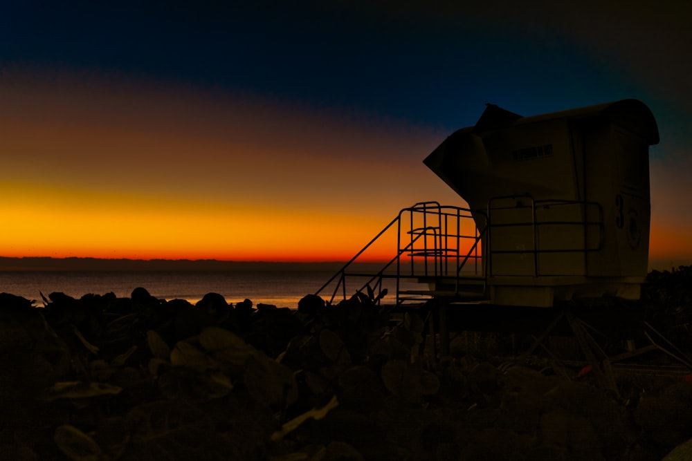 a lifeguard tower sitting next to a body of water