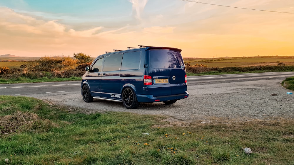 a blue van parked on the side of a road