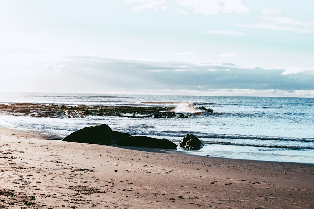 a person laying on a beach next to the ocean