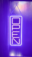 a neon sign hanging from the side of a building