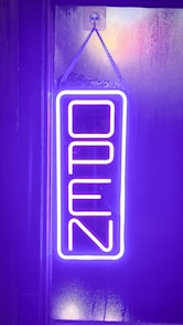 a neon sign hanging from the side of a building