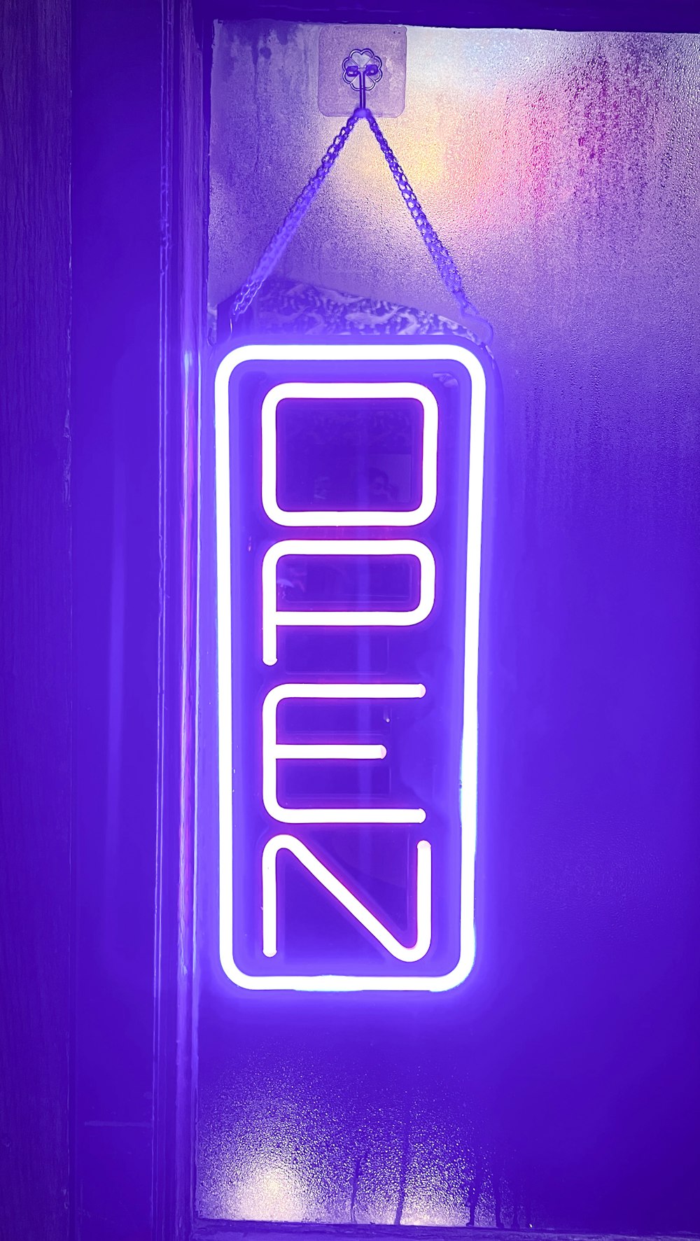 a neon sign hanging from the side of a building